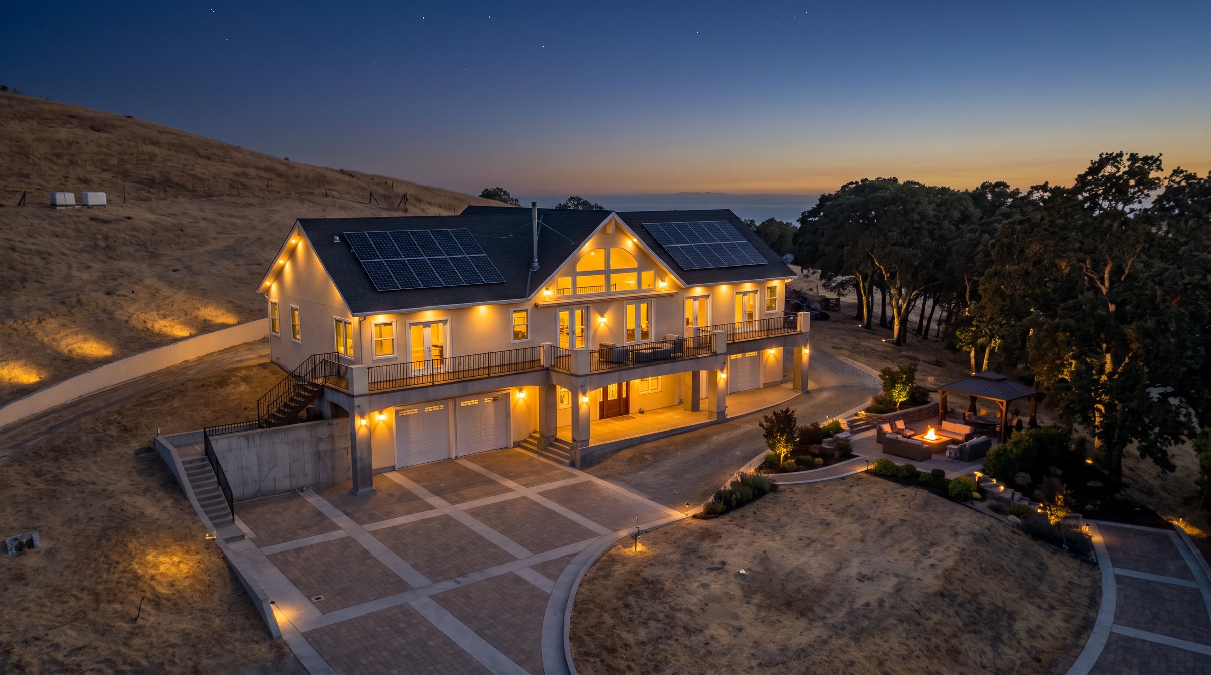 Luxury Clayton home aerial twilight view with glowing interior lights and outdoor lounge